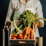 woman in white dress shirt holding green vegetable