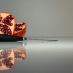 a cut open pomegranate on a reflective surface