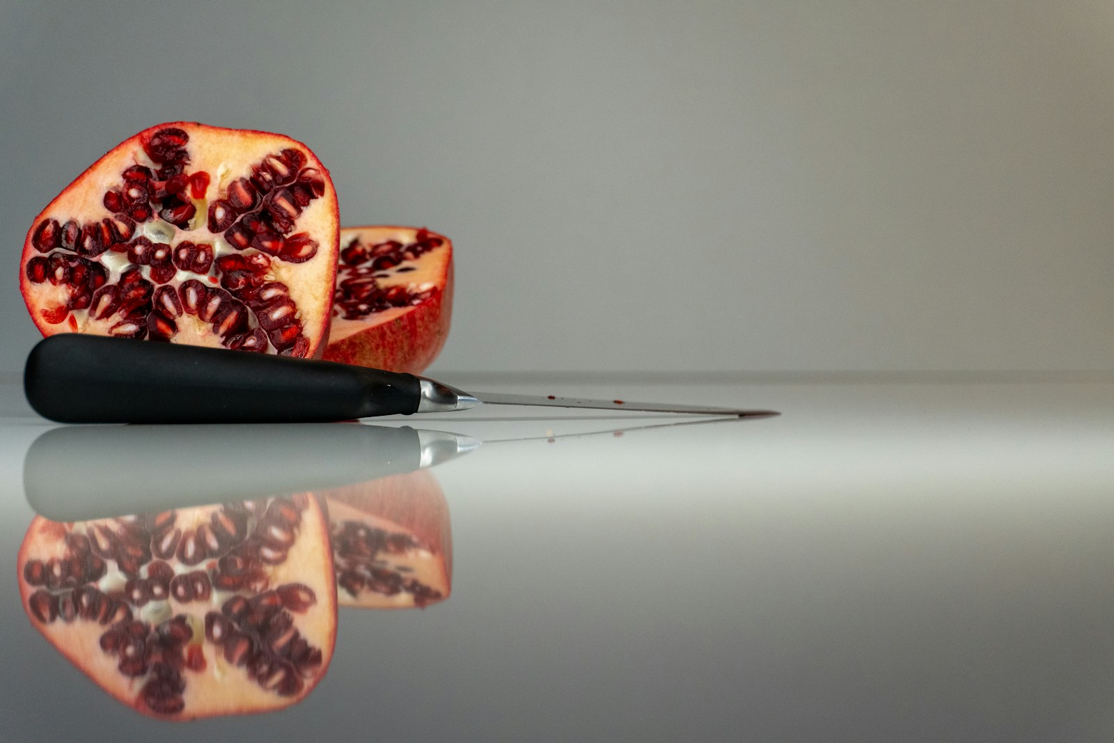 a cut open pomegranate on a reflective surface