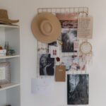 a hat is hanging on a white wall