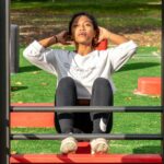 woman in white long sleeve shirt and black pants sitting on red metal frame